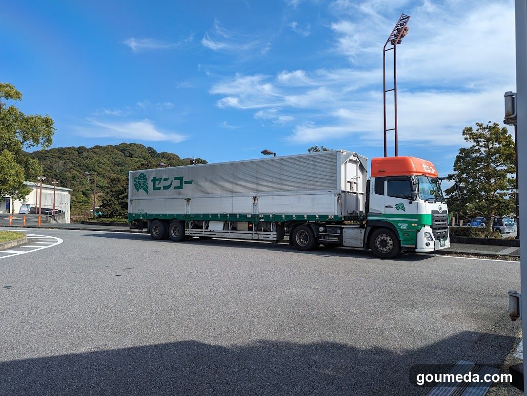 Truck with green and white trailer on a road
