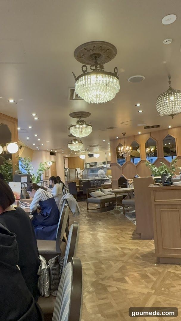 Interior of a restaurant or cafe with chandeliers and wooden flooring.