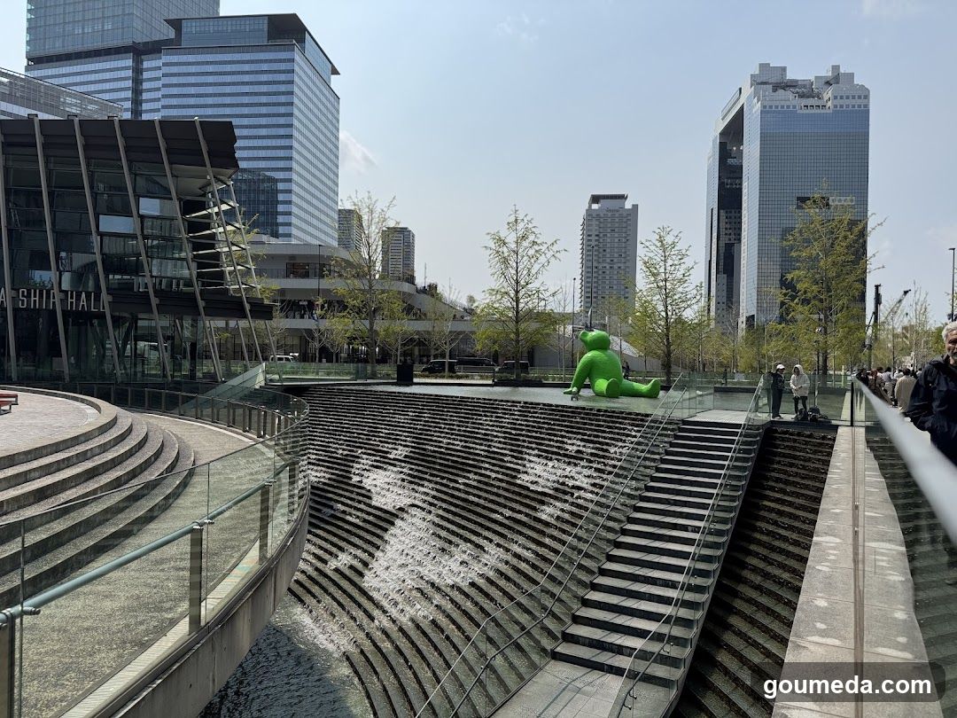 Urban plaza with water feature and green sculpture