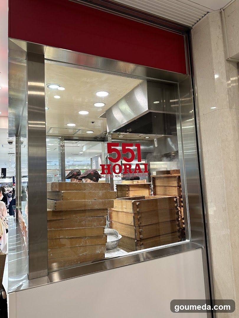 A photo of the exterior entrance or storefront facade of a shop named '551 HORAI', with visible signage on the building. The image shows stacks of wooden boxes inside, likely used for food preparation or storage.