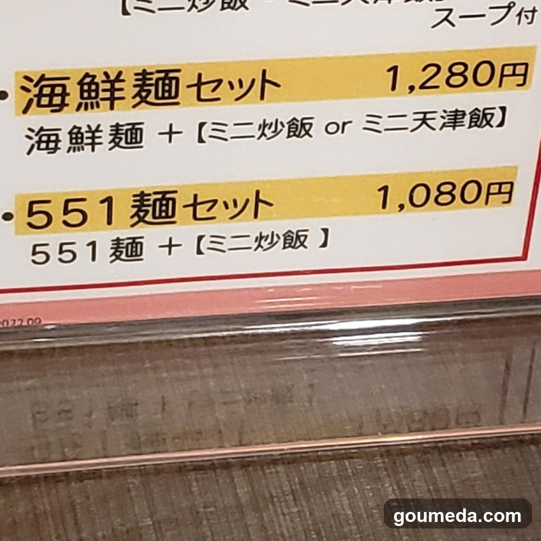 Close-up of a printed menu board displaying two noodle set options with prices in yen, featuring Japanese and English text.