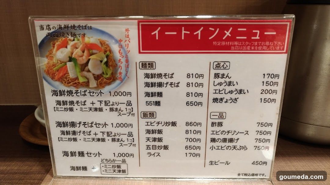 A menu board displaying seafood soba and rice dishes with prices in yen.