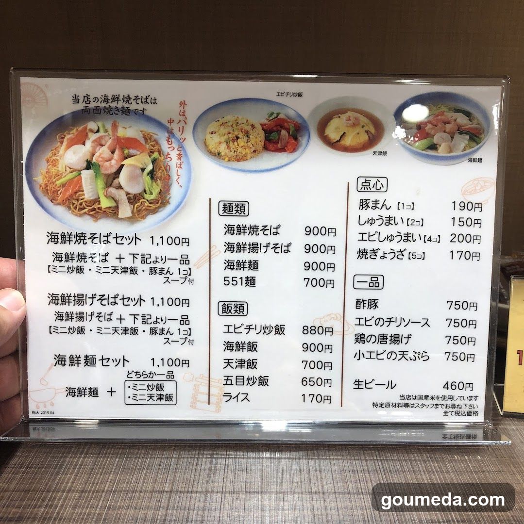 A close-up of a printed menu board featuring seafood dishes, including sets and rice options with prices in yen.