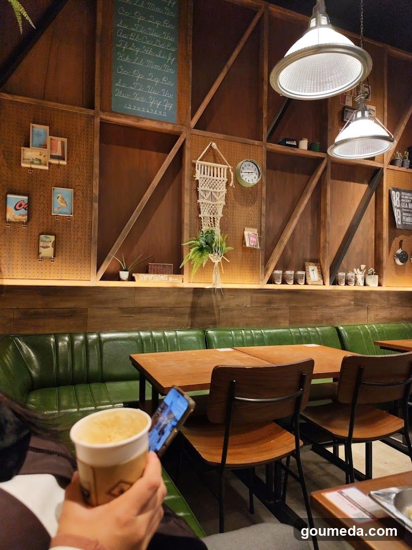 Interior of a cozy cafe with wooden decor and green booth seating.