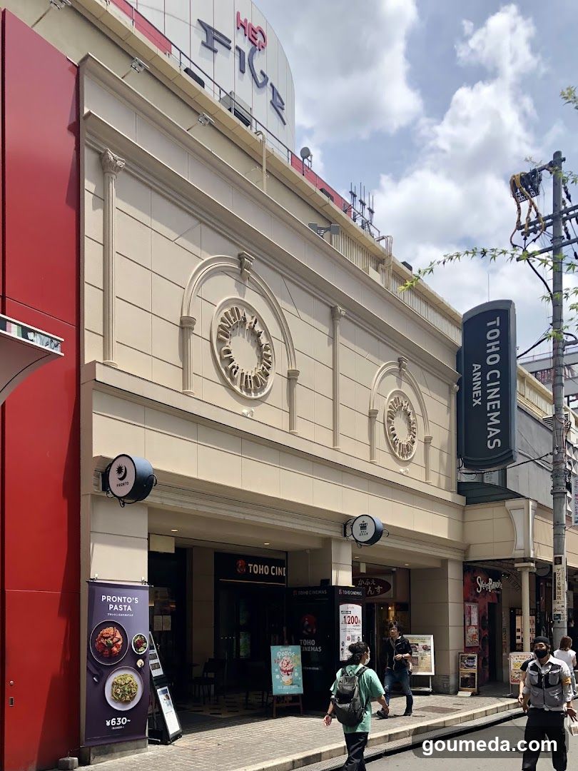 Exterior facade of TOHO CINEMAS ANNEX with visible signage, decorative circular motifs on the building, and adjacent Pronto's Pasta advertisement board.