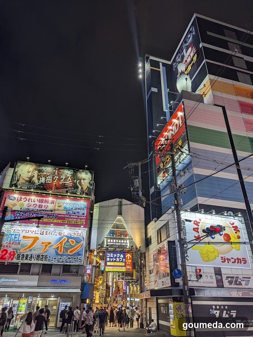 Night street scene with illuminated billboards and storefronts