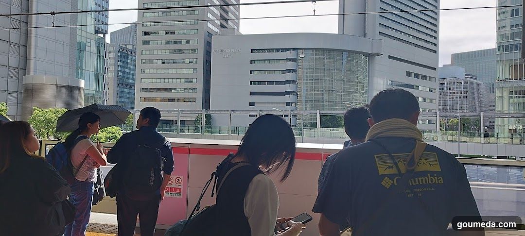 People waiting on a train platform in an urban area